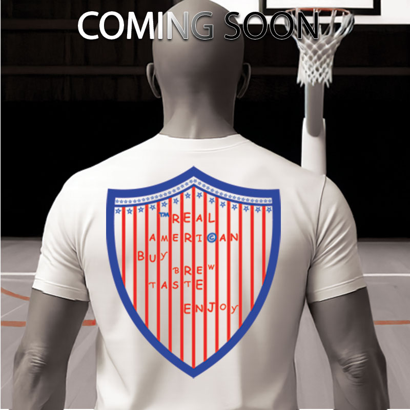 “Real American Patriot Edition t-shirt, full back shield logo with stars and stripes in red, white, and blue.”