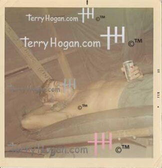 Jeffrey takes a break laying on his cot in his hooch with a beer.